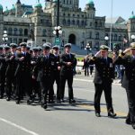 Cdr. Allyn Holborn salutes Rear-Admiral Nigel Greenwood for God Save the Queen in front of the Empress Hotel.
