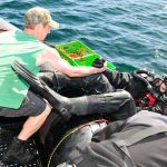 LS Litter helps fellow diver LS Marc Andre Ouimet get into the water for a dive.