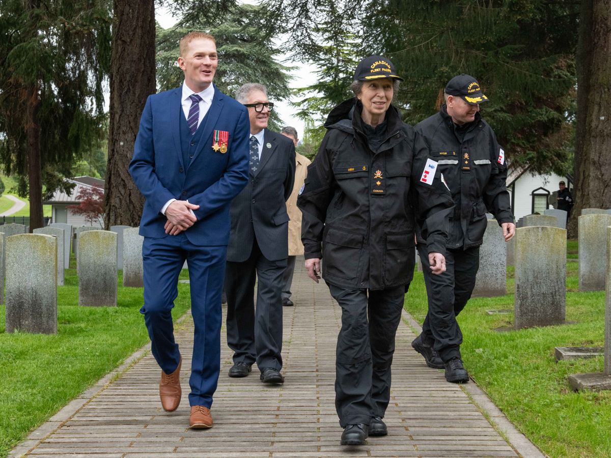 Son Altesse Royale visite le cimetière militaire God’s Acre à Esquimalt en compagnie du Commodore David Mazur (à droite), commandant de la Flotte canadienne du Pacifique, et d’un membre d’Anciens Combattants Canada. 
Photo : Caporal Jay Naples.