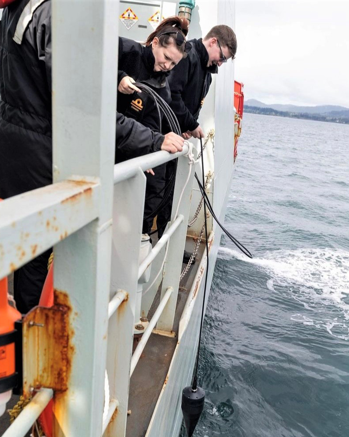 Sub-Lieutenant (SLt) Mitchell Coulombe and SLt Kayla Coletta deploy the underwater telephone from HMCS Yellowknife. Photos: Sailor 1st Class (S1) Brendan McLoughlin.