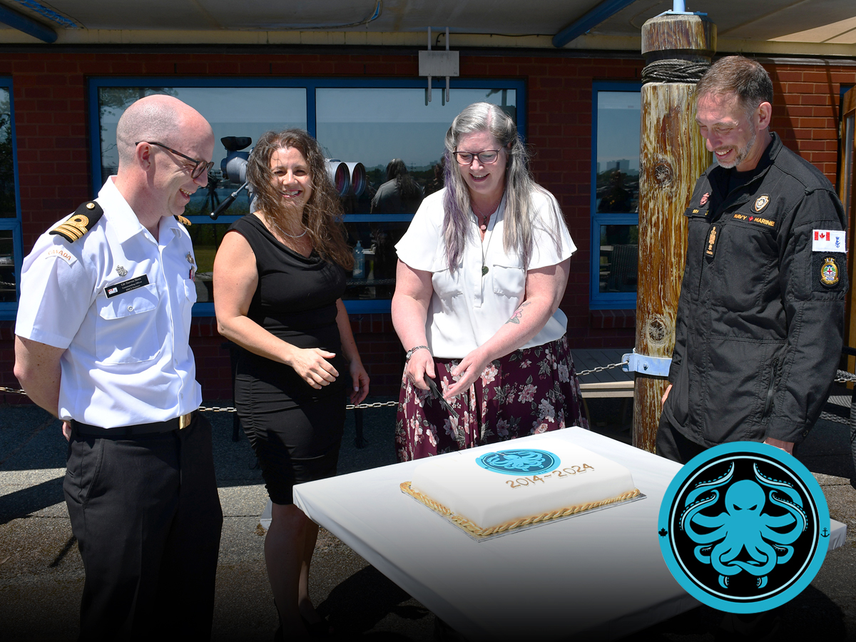 Commander Darren Sleen (left) and Chief Petty Officer 1st Class André Aubry (right) invite Josée Lafontaine and Laura Brackenbury to cut the cake.