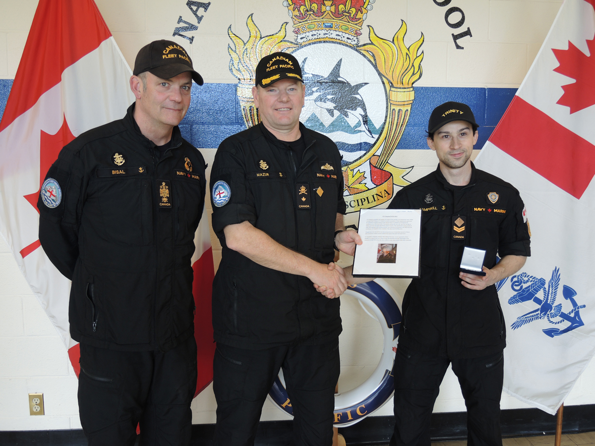 (Left) CPO1 David Bisal, Fleet Chief, and Commodore David Mazur, Commander Canadian Fleet Pacific, present Sailor 1st Class Nicholas Campbell with his Sailor of the Quarter certificate in a May 16 ceremony at Naval Fleet School (Pacific).
