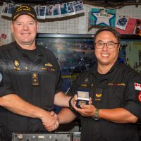 Commodore David Mazur, Commander Canadian Fleet Pacific, presents Sailor 1st Class Michael Fung with Sailor of the Quarter Coin aboard HMCS Ottawa docked at CFB Esquimalt on July 16. Photo: Sailor 3rd Class Mckayla Ryce, MARPAC Imaging Services