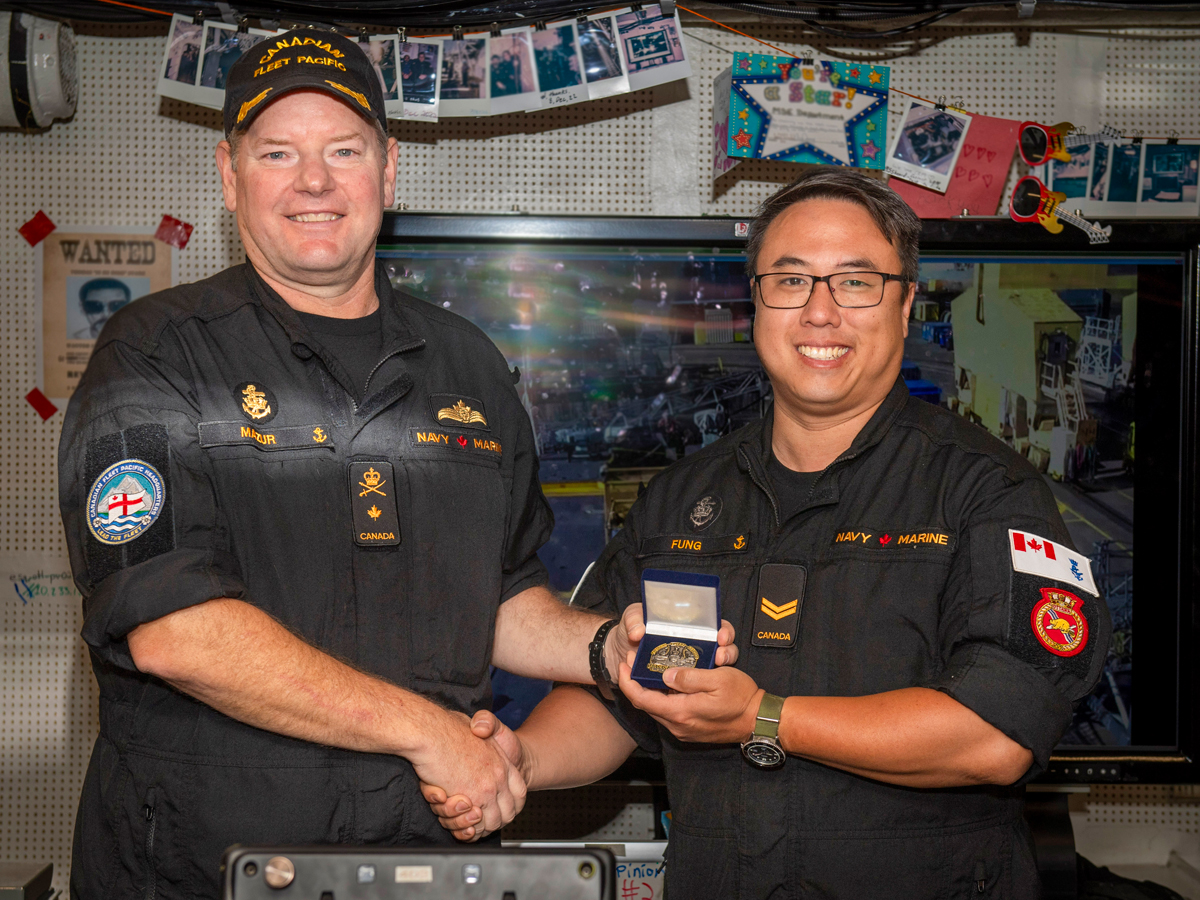 Commodore David Mazur, Commander Canadian Fleet Pacific, presents Sailor 1st Class Michael Fung with Sailor of the Quarter Coin aboard HMCS Ottawa docked at CFB Esquimalt on July 16. 
Photo: Sailor 3rd Class Mckayla Ryce, MARPAC Imaging Services