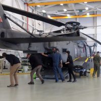 Family members learning the intricacies and details of the Sikorsky CH-148 Cyclone helicopter on display.