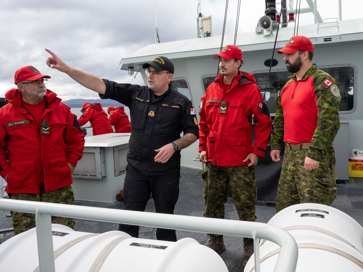 Acting Sub-Lieutenant Nowlan explains a man-overboard drill to members of 4 Canadian Ranger Patrol Group onboard Patrol Craft Training Grizzly as part of Exercise SEA RANGER while at sea en route to Alert Bay on Sept. 23.