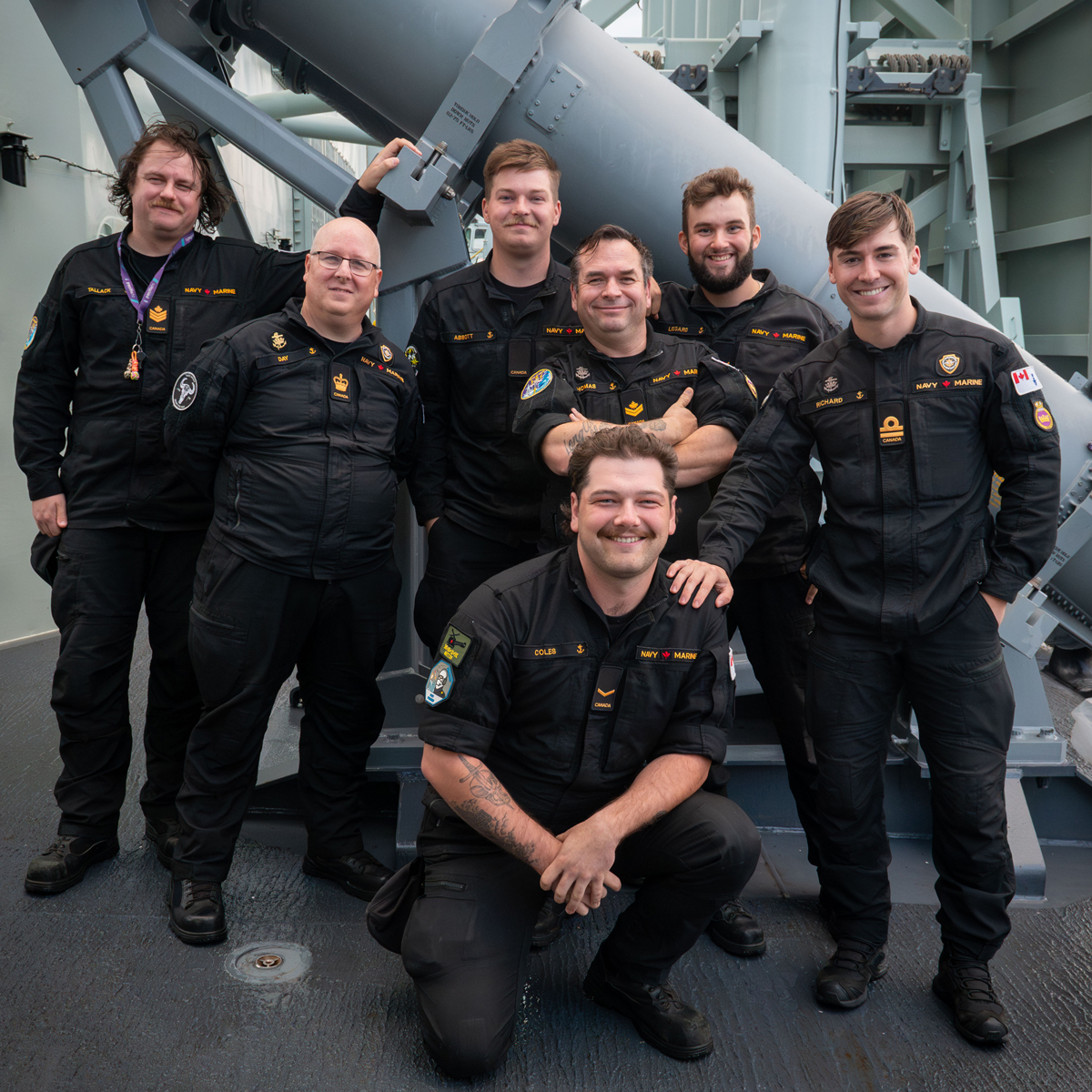 Group photo of HMCS Regina’s Naval Electronic Sensor Operators and supervising Officer, taken next to one of the ship’s Harpoon missile launchers off the coast of California.