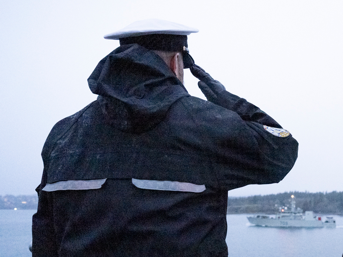 Le Contre-amiral C. Robinson, Capitaine de frégate des Forces maritimes du Pacifique, salue depuis le cap Duntze. Photo par : Caporal-chef André Maillet, Services d'imagerie des FMAR(P)