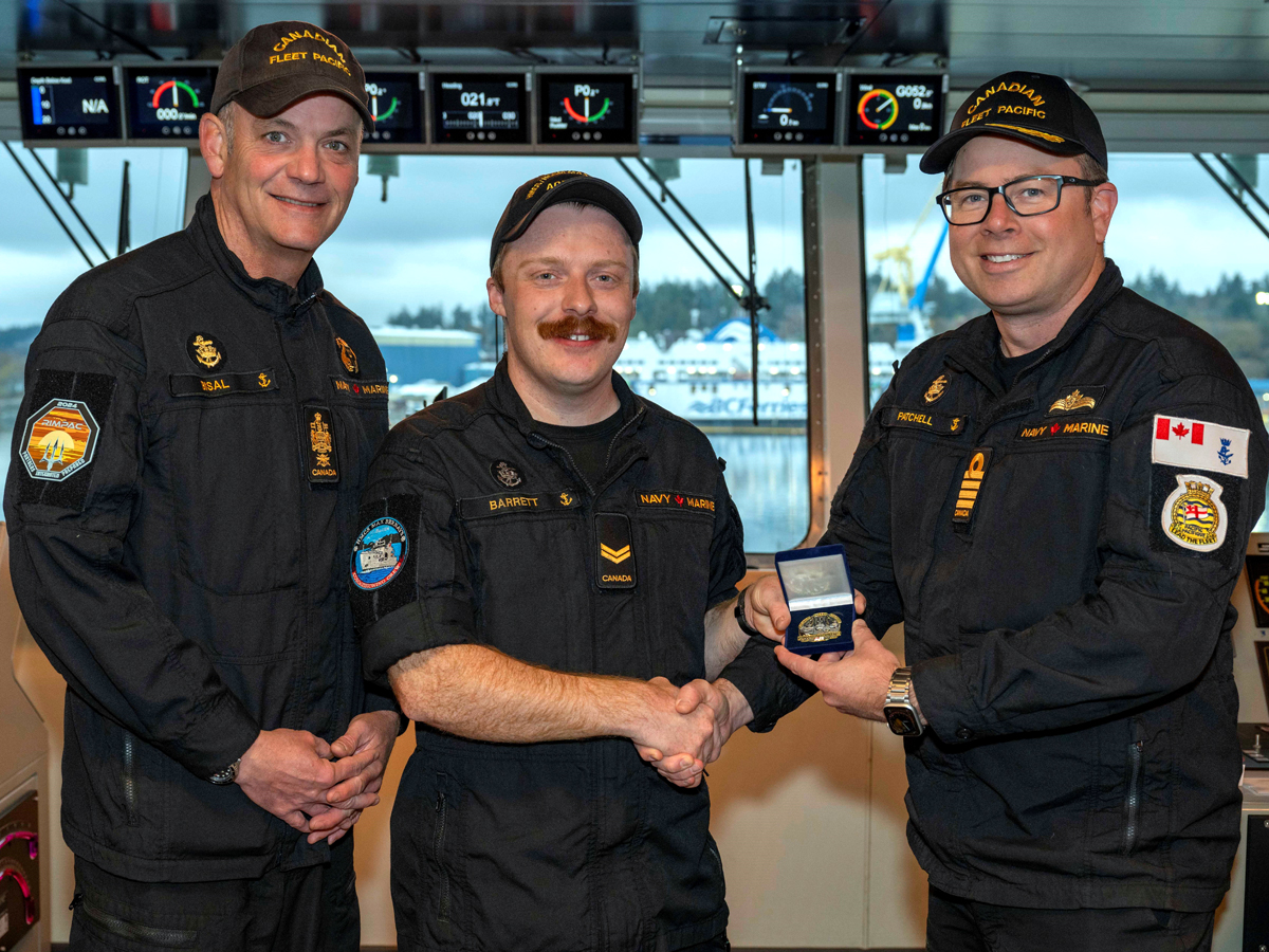 S1 Jacob Barrett is presented with the Sailor of the Quarter coin by Commander Sam Patchell, Deputy Commander of CANFLTPAC and CPO1 David Bisal, Fleet Chief on Sept. 16.