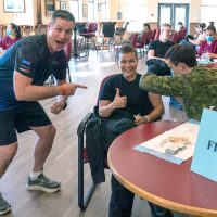 Base Commander Captain (Navy) Kevin Whiteside, Supports Base Chief Petty Officer Susan Frisby receiving immunization shots from the Vaccination Clinic at Wardroom.