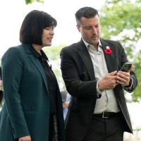 Minister of Veterans Affairs Canada and Associate Minister of National Defence Ginette Petitpas Taylor, left, and memory Anchor co-founder Ryan Mullens use the company’s interactive app during D-Day 80 services at the Bretteville-sur-Laize Canadian War Cemetery in Normandy, France. Photo: Veterans Affairs Canada