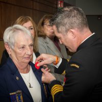 Base Commander Captain (Navy) Kevin Whiteside, pins a poppy onto Syvlia Vink, 1st Vice President and Poppy Chair of Royal Canadian Legion Branch 172 at the first poppy pinning ceremony held at the Chiefs & Petty Officers' Mess, Canadian Forces Base (CFB) Esquimalt on Oct. 25. Photo: Sailor 1st Class Brendan McLoughlin, MARPAC Imaging services