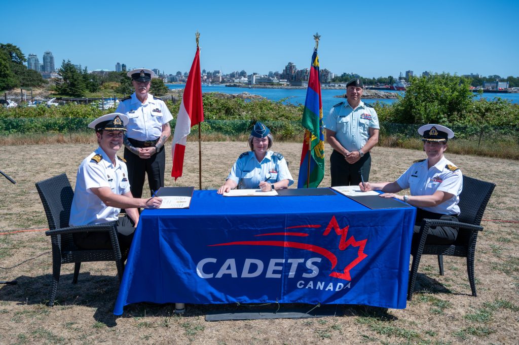 Cdr Benjamin Seaby, incoming CO, CPO1 David Bliss, Formation CWO Cadets and Junior Canadian Ranger Group, BGen Dominique Brais, Commander of Cadets and Junior Canadian Ranger Groupp, CWO David Shultz, RCSU (Pacific) CWO and Cdr Paula McHale, outgoing CO signing the Change of Command paperwork on July 7 2025