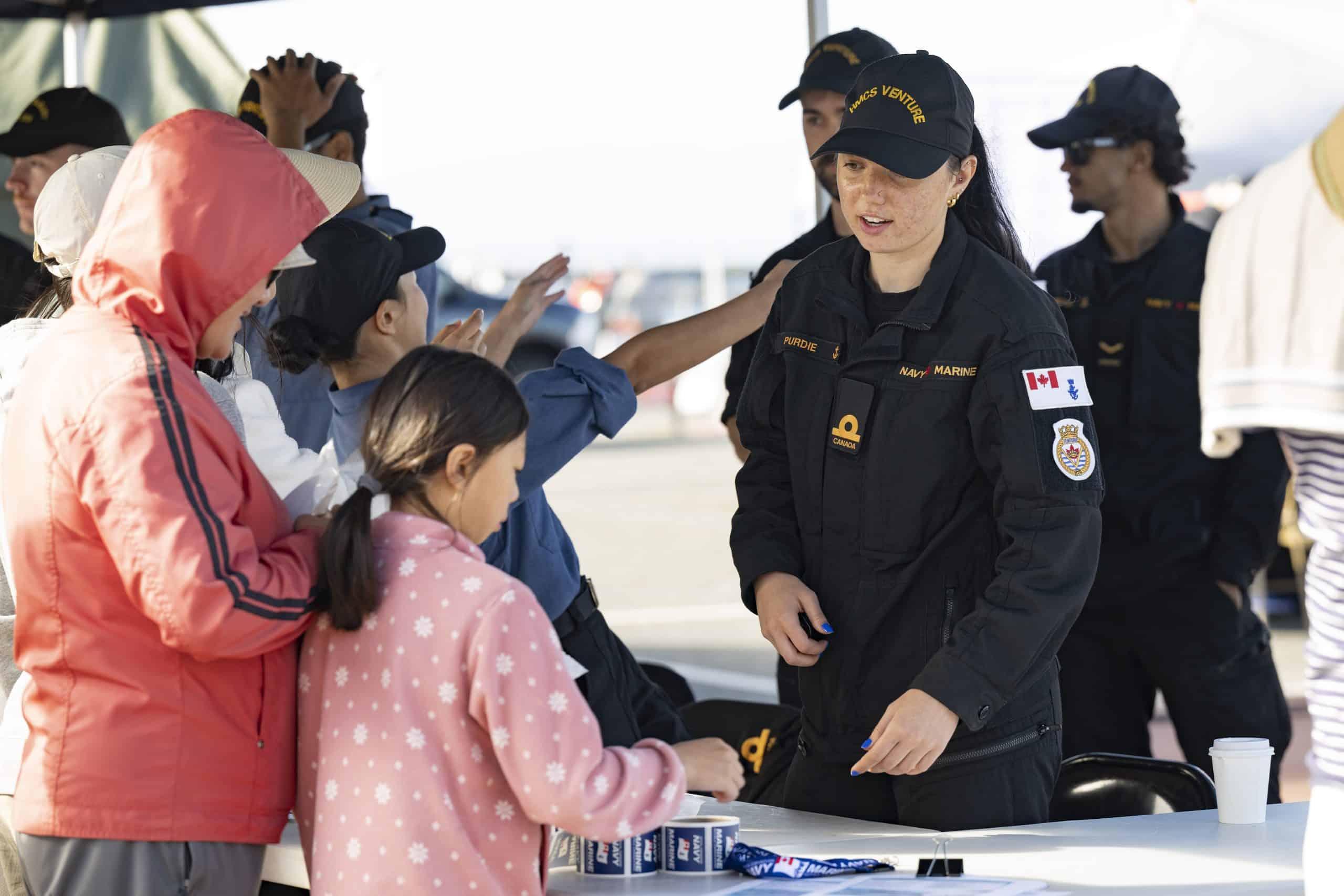 Locals engage with a member of the Royal Canadian Navy at one of many outdoor displays during Defence on the Dock 2023. Photo: Corporal Tristan Walach, Canadian Armed Forces