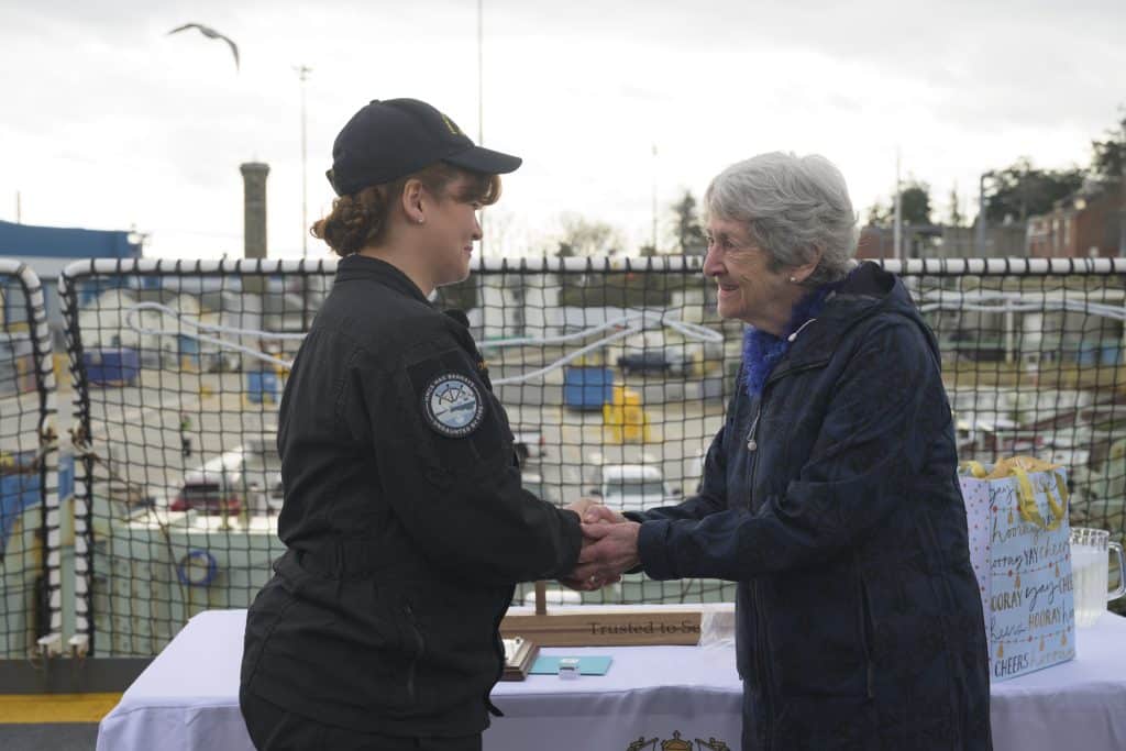 Mrs. Geraldine Hilton (right), the wife of the late Captain(Navy) Peter Hinton, warmly holds the hands of the 2025 Canadian Fleet Pacific
(CANFLTPAC) Sailor of the Year, Sailor 1st Class Andrée-Anne Dion-Tessier (left), during the presentation of the Capt(Navy) Peter Hinton Memorial Award for Leadership and Excellence in Service. Photo: Sailor 1st Class Jordan Schilstra, MARPAC Imaging